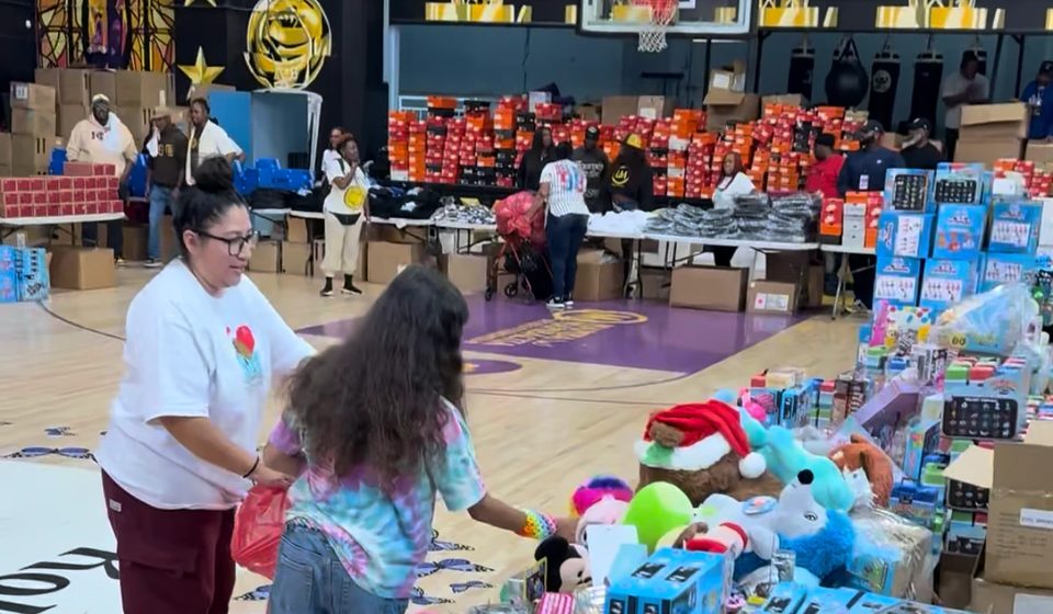 A volunteer helping a child choose a gift at a holiday toy giveaway